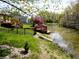 Inviting backyard with a deck overlooking a pond, complemented by mature trees and landscaping at 7987 Teal Dr, Coatesville, IN 46121