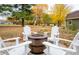 Backyard with barrel fire pit and four Adirondack chairs are surrounded by leaves in the fall at 8090 E 550 S, Zionsville, IN 46077