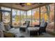 The screened-in porch has a wicker couch and two wicker chairs with a ceiling fan overhead at 8090 E 550 S, Zionsville, IN 46077