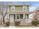 Charming two-story home with a welcoming front porch featuring brick columns and a well-maintained yard at 827 N Tacoma Ave, Indianapolis, IN 46201