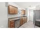 Well-lit kitchen with wood cabinets, stainless steel dishwasher and sink, providing a practical cooking space at 827 N Tacoma Ave, Indianapolis, IN 46201