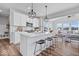 Modern kitchen featuring white cabinets, stainless steel appliances, a center island with bar seating, and hardwood floors at 8861 Linton Ln, Brownsburg, IN 46112