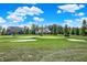 Expansive backyard view showcasing a pristine golf course and several stately homes on a bright day at 907 Oak Terrace Rd, Westfield, IN 46074