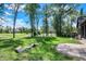 Serene backyard view with lush greenery, a stone patio, and neighboring homes in the distance at 907 Oak Terrace Rd, Westfield, IN 46074