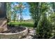 Beautifully landscaped backyard with stone retaining wall, lush lawn, and mature trees in a park like setting at 907 Oak Terrace Rd, Westfield, IN 46074