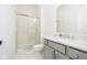 Modern bathroom features neutral tile, glass shower, and gray cabinets, exuding elegance at 907 Oak Terrace Rd, Westfield, IN 46074