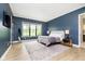 Modern primary bedroom with blue accent wall, floor-to-ceiling windows, and stylish, neutral-toned decor at 907 Oak Terrace Rd, Westfield, IN 46074