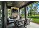 Covered patio with stone fireplace, TV, comfortable seating, and views of the lush green yard at 907 Oak Terrace Rd, Westfield, IN 46074
