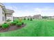 Expansive backyard featuring well-manicured lawn, landscaping, and view of neighboring homes at 9442 Orchard Cove Dr, Indianapolis, IN 46239