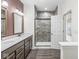 Bathroom featuring a walk-in shower, double vanity, and dark hardwood-style floors at 9442 Orchard Cove Dr, Indianapolis, IN 46239