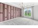 Spacious bedroom featuring a modern light fixture and floor-to-ceiling window with backyard view at 9442 Orchard Cove Dr, Indianapolis, IN 46239