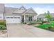 Charming home exterior with a two-car garage, stone accents and manicured landscaping at 9442 Orchard Cove Dr, Indianapolis, IN 46239
