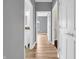 Hallway with wood floors, gray walls, and open doorways at 9657 Rialto Trl, Carmel, IN 46280