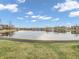 Large pond with neighborhood in the background, surrounded by grass, and a blue sky at 9657 Rialto Trl, Carmel, IN 46280