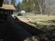 Backyard featuring a stone barbeque, an enclosed sunroom, and access to a wooden area at 10128 E Troy Ave, Indianapolis, IN 46239