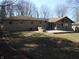 The backyard of this home features a concrete patio, stone barbeque and a sunroom with large windows at 10128 E Troy Ave, Indianapolis, IN 46239
