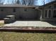Spacious backyard with a concrete patio and a stone barbeque featuring brick trim at 10128 E Troy Ave, Indianapolis, IN 46239