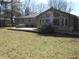 Spacious backyard with a concrete patio, a stone barbeque and views of the home's sunroom at 10128 E Troy Ave, Indianapolis, IN 46239