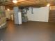 Basement featuring painted concrete flooring and utilities, suitable for storage or finishing at 10128 E Troy Ave, Indianapolis, IN 46239