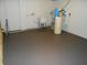 Functional basement area with utility sink, water tanks, and painted concrete flooring at 10128 E Troy Ave, Indianapolis, IN 46239