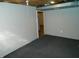 Basement room with carpet flooring, light gray walls, and access to storage area at 10128 E Troy Ave, Indianapolis, IN 46239
