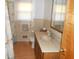 Bathroom features a vanity with cream countertop, window, and seashell curtain at 10128 E Troy Ave, Indianapolis, IN 46239