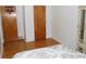 Modest bedroom features wood floors, white walls, and multiple doors at 10128 E Troy Ave, Indianapolis, IN 46239