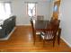 Dining room with hardwood floors, classic wooden table, and leather sofa in the living space at 10128 E Troy Ave, Indianapolis, IN 46239