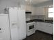 View of the kitchen featuring white cabinetry, stainless steel appliances, and dark countertops at 10128 E Troy Ave, Indianapolis, IN 46239