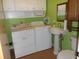 Laundry area with sink, pedestal sink, upper cabinets, and side by side washer and dryer at 10128 E Troy Ave, Indianapolis, IN 46239