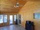 Sunroom featuring tile floor, wood paneled walls, ceiling fan, and access to outdoors at 10128 E Troy Ave, Indianapolis, IN 46239