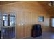 Cozy sunroom with wood paneling on the walls, ceiling fan, and door to outside at 10128 E Troy Ave, Indianapolis, IN 46239
