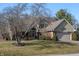 View of home with brick facade, arched entryway, with a well-manicured lawn and mature trees at 1110 Butternut Dr, Columbus, IN 47201
