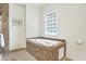 Bright bathroom featuring a tiled jacuzzi tub under a glass block window, complete with neutral-toned tiling at 1111 Fletcher Ave, Indianapolis, IN 46203