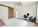 Modern bedroom with a sleek sliding barn door, a desk, and an inviting accent chair, bathed in natural light at 1111 Fletcher Ave, Indianapolis, IN 46203