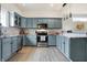 Modern kitchen featuring blue cabinets, stainless steel appliances, marble countertops, and hardwood floors at 1111 Fletcher Ave, Indianapolis, IN 46203
