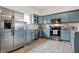 Modern kitchen featuring blue cabinets, stainless steel appliances, marble countertops, and hardwood floors at 1111 Fletcher Ave, Indianapolis, IN 46203