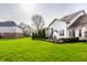 Lush backyard featuring green lawn, mature trees, and a patio with outdoor seating and grill at 11686 Belle Plaine Blvd, Fishers, IN 46037
