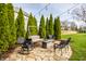 Backyard seating area with outdoor furniture, mature landscaping, string lights, and privacy fence at 11686 Belle Plaine Blvd, Fishers, IN 46037