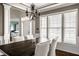Bright dining room featuring a chandelier, large windows, and modern wood table at 11686 Belle Plaine Blvd, Fishers, IN 46037