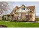 Beautiful two-story home featuring stone accents, a covered porch, and blossoming landscape at 11686 Belle Plaine Blvd, Fishers, IN 46037