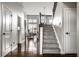 Hallway featuring hardwood floors, staircase, and views into adjacent living spaces at 11686 Belle Plaine Blvd, Fishers, IN 46037