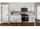 Modern kitchen with stainless steel appliances, white cabinets, a gas range, and tile backsplash, perfect for cooking and entertaining at 11686 Belle Plaine Blvd, Fishers, IN 46037