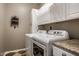 Functional laundry room with white cabinetry, granite countertop, and modern washer and dryer units at 11686 Belle Plaine Blvd, Fishers, IN 46037