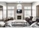 Cozy living room with a fireplace, large windows, and comfortable seating arrangement at 11686 Belle Plaine Blvd, Fishers, IN 46037