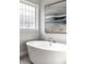 Elegant soaker tub with modern fixtures and a beautiful mosaic window in the main bathroom at 11686 Belle Plaine Blvd, Fishers, IN 46037