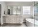 Bright main bathroom featuring a large mirror, dual vanity, and a soaker tub at 11686 Belle Plaine Blvd, Fishers, IN 46037