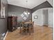 Dining room with dark grey walls, wooden table, and chair set underneath a modern light fixture at 12610 Broadmoor N Ct, Fishers, IN 46037