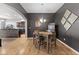 Dining room with hardwood flooring, modern light fixture, dark walls and entry to the kitchen at 12610 Broadmoor N Ct, Fishers, IN 46037