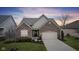 Charming brick home featuring an attached two-car garage, manicured lawn and attractive landscaping at 12610 Broadmoor N Ct, Fishers, IN 46037